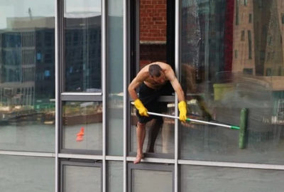 mężczyzna myjący okna